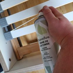 Application de la terre de diatomée DIATOZEN dans les interstices du sommier en bois