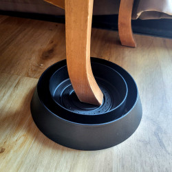 Mise en place d'un piège anti punaise de lit SENTINELLE sous un pied de meuble en bois