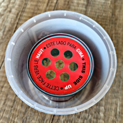 La boîte en plastique contient l'eau ajoutée. On imerge ensuite la boîte rouge dedans pour activer FUMICHOC mites alimentaires.