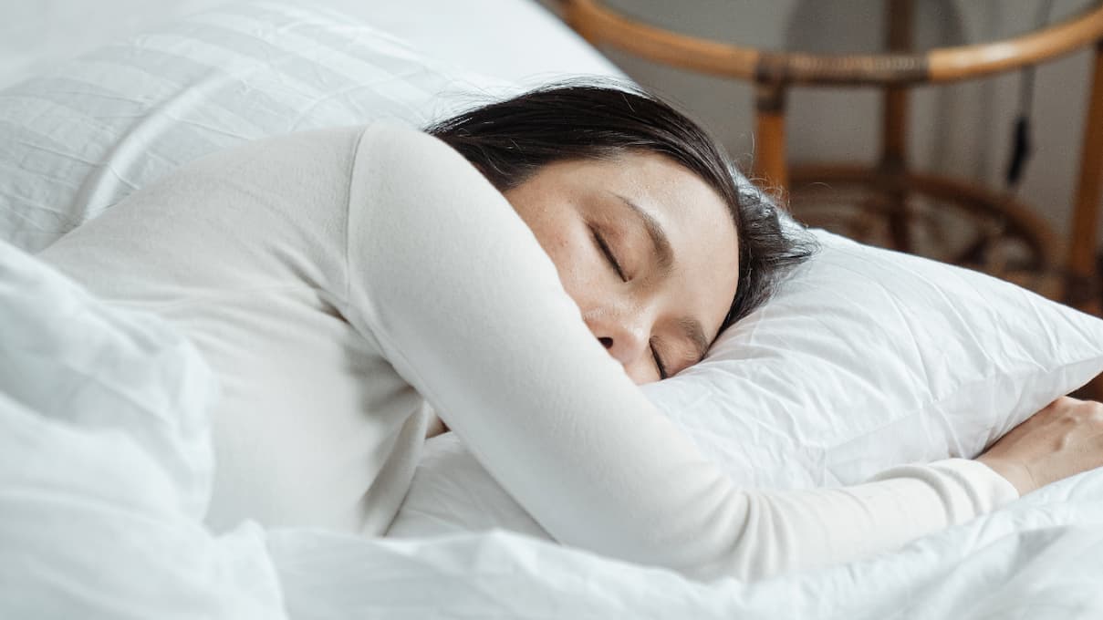 Femme se reposant dans un lit d'hôtel